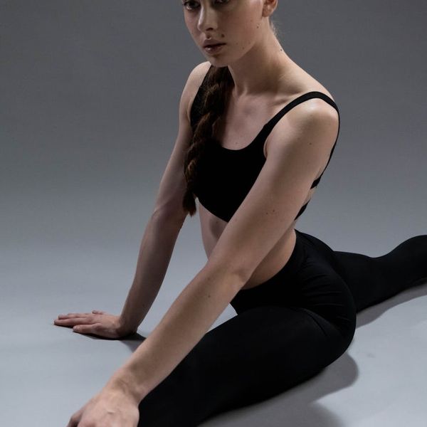 Athlete stretching, showing flexibility and control in a minimalist environment.